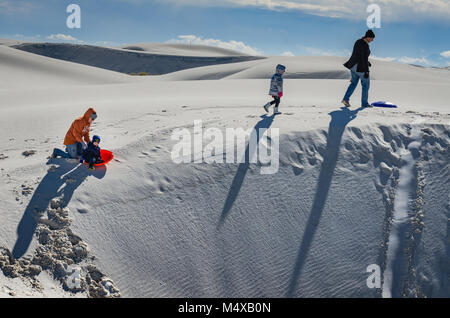 Schlitteln auf dem schönen weichen Gips Sand im White Sands National Monument in New Mexico ist eine beliebte Aktivität und Spaß für Kinder und Erwachsene Stockfoto