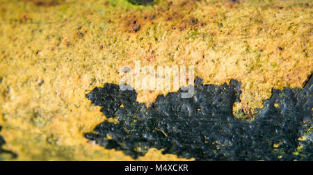 Rostiges Metall teil mit Resten von schwarzer Farbe Stockfoto