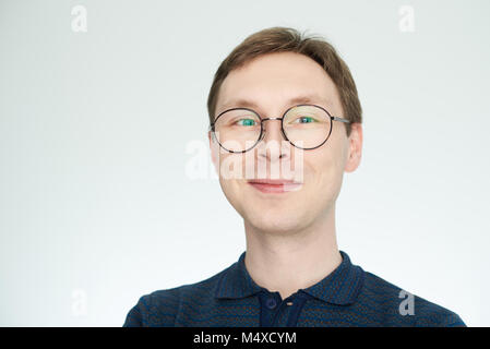 Fröhliche positive Suchen junger Mann in Gläser auf weißem Hintergrund Stockfoto