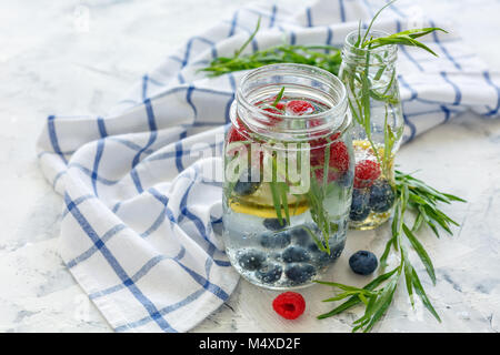 Beeren und Estragon in Glas mit Mineralwasser. Stockfoto