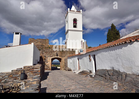 Mittelalterliche Stein gepflasterte Gasse mit weiß getünchten Häusern und Glockenturm Stockfoto