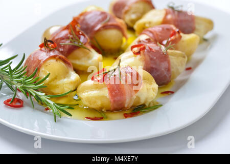 Hot Rosmarin Kartoffeln gefüllt mit Käse und Südtiroler Speck umwickelt, gebacken in Olivenöl mit Chili Schichten Stockfoto