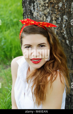 Mädchen sitzt auf einer Birke im herbstlichen Wald Stockfoto