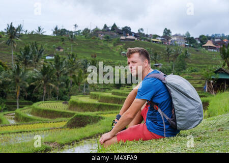 Junger Mann Reisender Sitzen und Entspannen im Freien Stockfoto