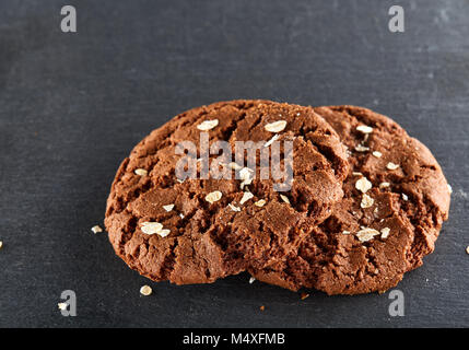 Chocolate Chips cookies mit Haferflocken Chips auf schwarzem Hintergrund, Makro isolierten dekoriert, close-up Stockfoto