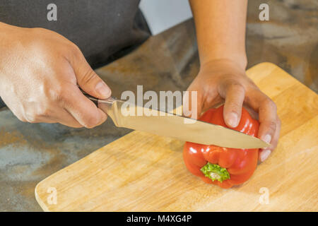 Koch schneiden Red Paprika auf Holz Breite Stockfoto