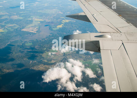 Felder und Wälder unter dem Flügel des Flugzeugs, der Blick aus dem Fenster eines Flugzeuges, Reisen in der Ebene Stockfoto