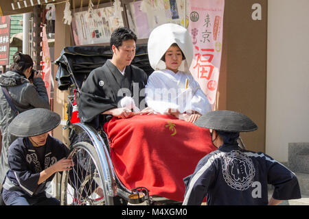 Ein paar Heiraten an der Sensō-ji-Tempel in Asakusa, Taitō, Tokio, Japan. Sie werden an der Rezeption in einem Rrickshaw genommen. Stockfoto