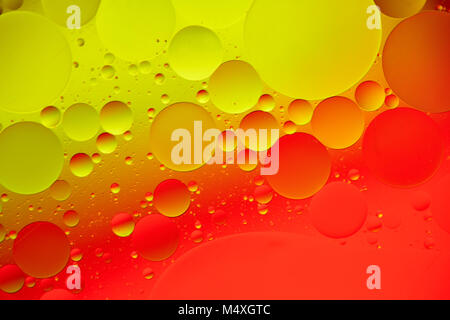 Mischen von Wasser und Öl, schöne Farbe abstrakt Hintergrund zu den roten und gelben Kreise und Ellipsen, Makro Abstraktion. Unrealistisch bunte Blasen, Stockfoto