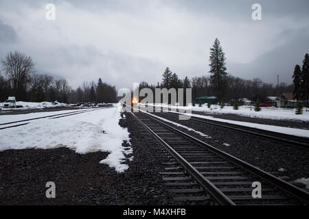 Ein BNSF train unten kommen die Tracks in die Stadt Troja, Montana Stockfoto