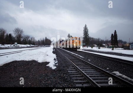 Ein BNSF train unten kommen die Tracks in die Stadt Troja, Montana Stockfoto