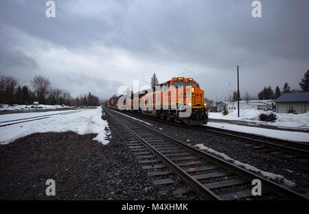 Ein BNSF train unten kommen die Tracks in die Stadt Troja, Montana Stockfoto