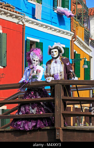 Ein schönes romantisches Paar während des Karnevals von Venedig (Carnevale di Venezia) auf einer Brücke in Burano (Venedig), Italien Stockfoto