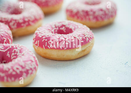 Donut. Süße Puderzucker essen. Dessert bunte Snack. Glasierte Streuseln. Behandeln von leckeren Gebäck Frühstück. Bäckerei Kuchen. Donut mit Zuckerguss. Gebackene ungesunde Runde Stockfoto