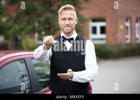 Porträt einer Stattlichen männlichen Valet Holding Autoschlüssel im Freien Stockfoto