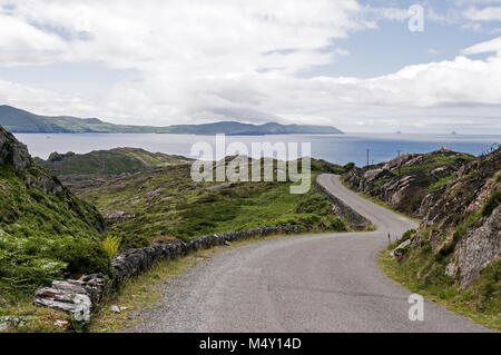 Eine schmale Küstenstraße, Teil des Ring of Beara in Südirland, gegenüber der Kenmore Bay zwischen Allihies und Eyeries auf der Beara-Halbinsel. Stockfoto