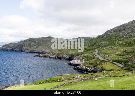 Eine schmale Küstenstraße, Teil des Ring of Beara in Südirland, gegenüber der Kenmare Bay zwischen Allihies und Eyeries auf der Beara-Halbinsel. Die R Stockfoto