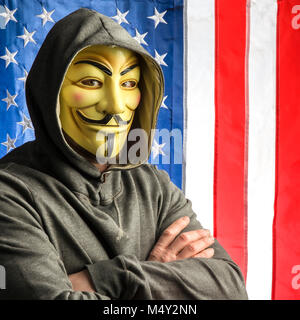 Mailand, Italien, Februar 2018: Hacker Kreuzung Waffen tragen anonymus Maske mit amerikanischen Old Glory Flagge im Hintergrund. Editorial Foto. Stockfoto