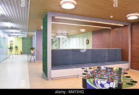 Table soccer in a large office room. Interior of the staff rest room in the modern office of the business center. A table football game near a long so Stockfoto