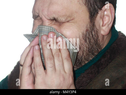 Der kranke Mann mit dem Niesen in ein Taschentuch Stockfoto