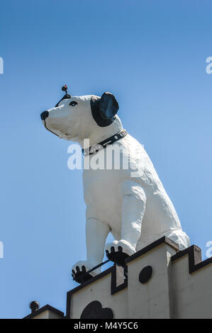 Weißer hund Statue, Bildnis des RCA-Maskottchen Nipper, oben auf einem Gebäude mit einer hellen blauen Himmel Hintergrund thront, in Albany, New York. Stockfoto