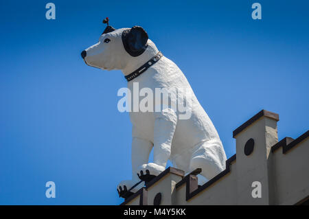 Weißer hund Statue, Bildnis des RCA-Maskottchen Nipper, oben auf einem Gebäude mit einer hellen blauen Himmel Hintergrund thront, in Albany, New York. Stockfoto