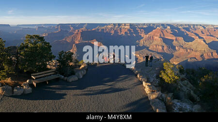 Entlang der historischen Einsiedler Straße auf der South Rim, Powell Point bietet einen atemberaubenden 200° Blick auf die Grand Canyon. Die Sicht, und der Stein Memorial Hier gelegen, erinnern an die 1869 und 1871-72 Explorative Fluss Reisen durch den Grand Canyon, die auf dem Colorado River von Major John Wesley Powell und seine Crew Mitglieder. Dieses Bild zeigt den Bereich am nördlichsten Ende der Punkt, dass nur über den Stein Memorial befindet. Laden Sie sich unsere 2018 Grand Canyon Trip Planner: Vier Touristen anzeigen Grand Canyon Am Ende Des breiten gepflasterten Bereich an der Powell Point. Auf der linken Seite, eine Holzbank, die durch T SCHATTIERT IST Stockfoto