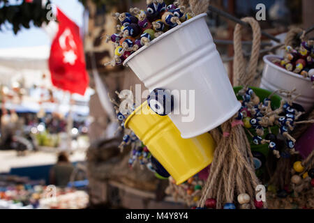 Dekorative Objekte mit bösen Augen gemacht. Türkische Flagge Wellen im Hintergrund im Cunda (alibey) Insel. Stockfoto