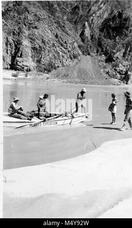 AL MILLOTE, HOLLYWOOD FOTOGRAF, Sprünge AN LAND ALS ERSTES SCHIFF DER NEVILLS 5. COLORADO EXPEDITION STRÄNDE AUF der Bright Angel Creek. NEVILLS' Frau und Tochter TREFFEN SIE AM STRAND. Fotograf J.M. EDEN. CIRCA 1984. Grand Canyon Nat Park historische Fluss Foto. Stockfoto