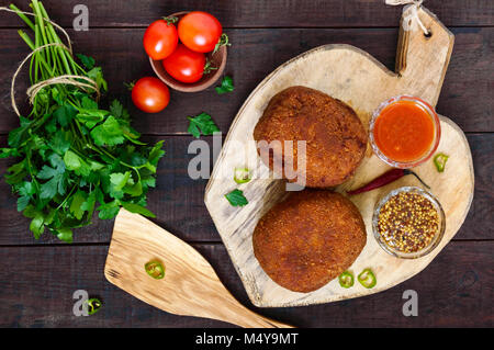 Große saftige Schnitzel gefüllt mit gekochtem Ei auf einem Schneidebrett auf einem dunklen Hintergrund. Schottische Schnitzel. Die Ansicht von oben Stockfoto