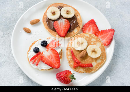 Lustig bunten Frühstück Pfannkuchen mit Tier von Flächen für Kinder auf weiße Platte. Ansicht von oben Stockfoto