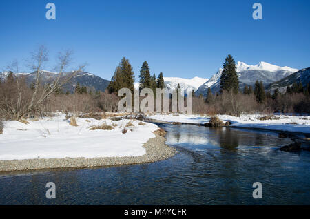 Ein im Bull River Bend, wie es Wind nach Norden durch das Kabinett in den Bergen, mit Ibex Peak und Schneeschuh Gipfel in der Ferne, an einem kalten, klaren Tag. Stockfoto