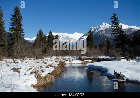 Bull River, North, mit Ibex Peak und Schneeschuh Gipfel im Kabinett Berge in der Ferne, an einem kalten, klaren Tag. Stockfoto