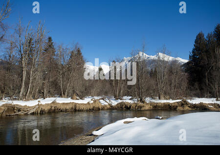 Bull River, North, mit Ibex Peak und Schneeschuh Gipfel im Kabinett Berge in der Ferne, an einem kalten, klaren Tag. Stockfoto