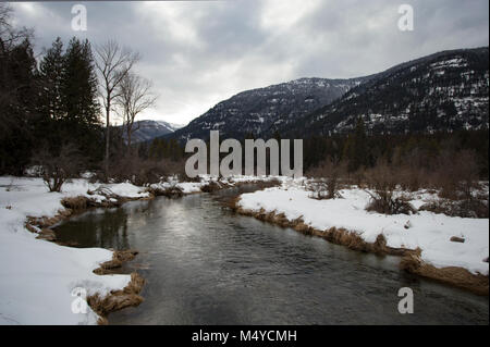 Bull River Wicklung südlich durch das Kabinett Berge an einem kalten, bewölkten Tag. Stockfoto