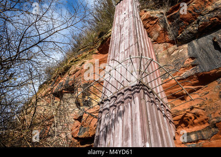 Ein Metall rutsche Struktur mit einem Security Barrier in Sandsteinfelsen. Stockfoto