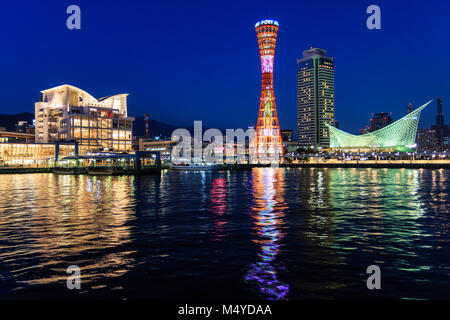 Japan, Kobe. In der Nacht Blick auf das beleuchtete Rote Port Tower, mit ikura Hotel und Maritime Museum. Lichter im Meer wider. Stockfoto