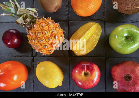 Eine Vielzahl von bunten Früchte auf schwarze Quadrate aus Schiefer Stein Stockfoto