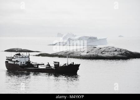 Einsames Fischerboot in die Diskobucht Ilulissat-eisfjord im Juli - eisberge - Schwarz und Weiß Stockfoto