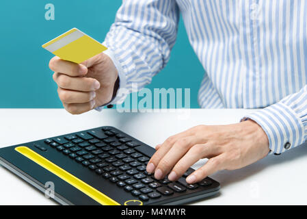 Man Hände mit der Tastatur und der Holding Kreditkarte Stockfoto