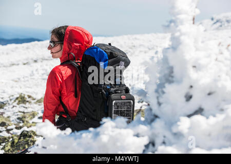 Ansicht der Rückseite Frau Ruhe beim Wandern im Winter in den White Mountains, New Hampshire, USA Stockfoto