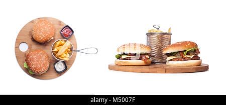 Zwei selbstgemachte Burger auf Holzplatte auf schwarzem Hintergrund, zwei Cheeseburger auf der Holzplatte. Frühstück mit Hamburger und Pommes Frites, k Stockfoto