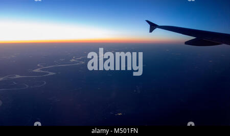 Fliegen bei Nacht über Städte unter Stockfoto