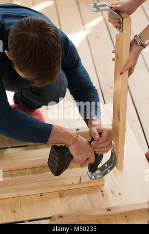 Nicht erkennbare Paar Umzug in neues Zuhause Haus. Auspacken der Kartons und Zusammenbau von Möbeln Stockfoto