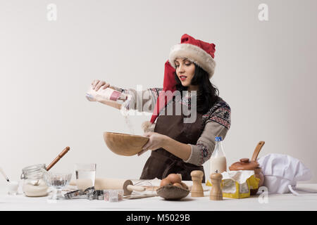 Glückliche junge Hausfrau macht Weihnachtsplätzchen in Küche Stockfoto