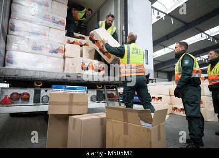 19. Februar 2018, Deutschland, Kiel: Kartons mit geschmuggelten Zigaretten und einige pet-Wurf für verschleiern gefüllt werden vor einem Lkw gesehen werden. Die Zollstelle der Kieler Hafen präsentiert 6, 6 Millionen geschmuggelte Zigaretten während einer Veranstaltung. Die Zigaretten wurden auf der Werft in Skandinavien Travemünde am 7. Februar gesichert. Foto: Christian Charisius/dpa Stockfoto