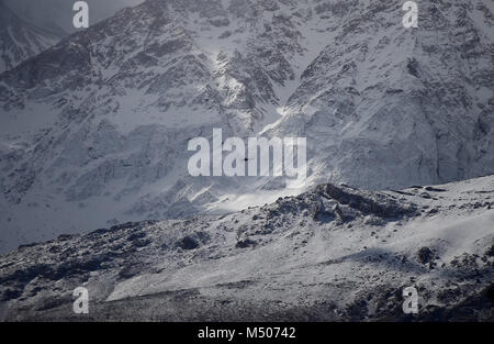 Die dena, Iran. 19 Feb, 2018. Ein Hubschrauber fliegt über die Berge auf der Suche nach dem Wrack eines Passagierflugzeuges, die am Sonntag an der Dena Berg stürzte, zentralen Iran am 19.02.2018. Iran gefunden das Wrack des abgestürzten Aseman Airlines ATR-72 Flugzeug am Montag und erhielt Beileid aus dem Chinesischen, Russischen und der Vereinten Nationen (UN) Führer für die Opfer der Incident- und deren Familien. Credit: Arya Jafari/Xinhua/Alamy leben Nachrichten Stockfoto