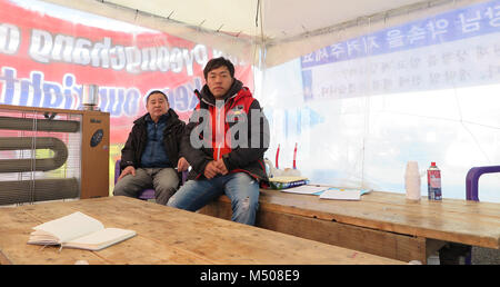 17 Februar 2018, Südkorea, Pyeongchang: Der Eigentümer eines Ski- und Snowboard Verleih, Bae sang Beom (R), der in einem Zelt außerhalb des olympischen Bereich mit einem Kollegen protestieren gegen die vollständige Schließung des kommerziellen ski Business im Phoenix Park. Die Teilnehmer der Kundgebung haben erhebliche wirtschaftliche Verluste zu akzeptieren. Mehrere Wettbewerbe in der Freestyle Skifahren und Snowboarden sind in das Skigebiet während der Olympischen Spiele in Pyeongchang. Foto: Dirk Godder/dpa Stockfoto