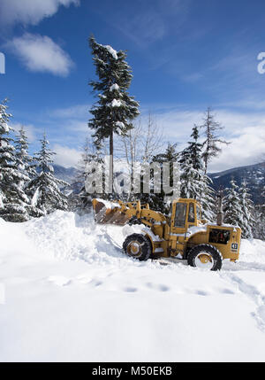 Noxon, Montana, USA. 19. Februar, 2018. Snow event. Ein Caterpillar 950 mit Gummibereifung artikuliert Lader Schneeräumen auf einem Berg Straße nördlich des Noxon, in Sanders County Montana. Der Lader wird von delbert Bowe von Libby, Montana betrieben. Die Straße ist in einem abgelegenen Teil des Schrankes Bergen, etwa 20 km nördlich von Noxon, Montana. Die Gegend war mit schweren Schnee, die aus dem Westen über das Wochenende kam, das mehrere Tage dauerte und Gedumpten über 20 Zentimeter Schnee in den Höhenlagen. Stockfoto