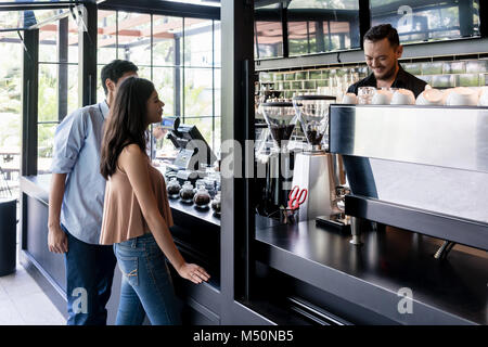 Junges Paar vor der Theke eines trendigen Co Stockfoto